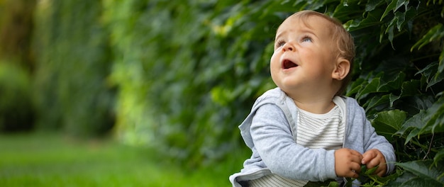 自由レクリエーションと子供の頃のコンセプトコテージヤードの緑の芝生で暖かい夏の日を楽しんで屋外で幸せな子供