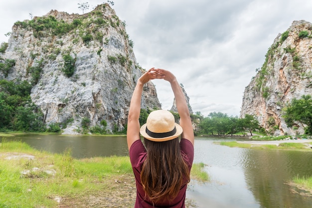 Freedom traveler woman in nature on mountain with raised arms enjoying happiness