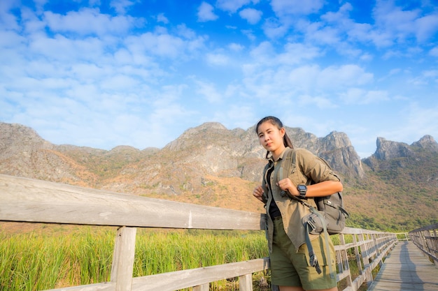 腕を上げて立って、美しい自然を楽しんで、若い応援する自由旅行者の女性