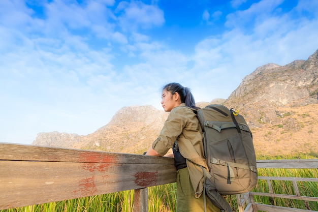 Freedom traveler woman standing with raised arms and enjoying a beautiful nature and cheering young