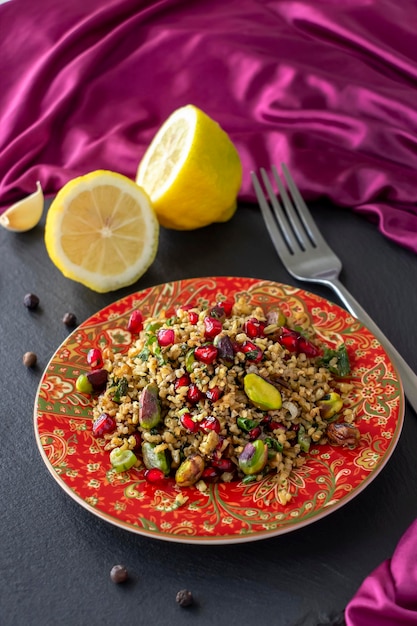 Freekeh pomegranate seeds and pistachio healthy salad Arabic African and Arabic traditional cuisine Copy space Superfood concept