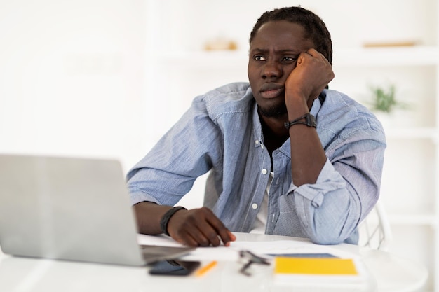 Freelance Burnout Portrait Of Bored Black Man Sitting At Desk With Laptop