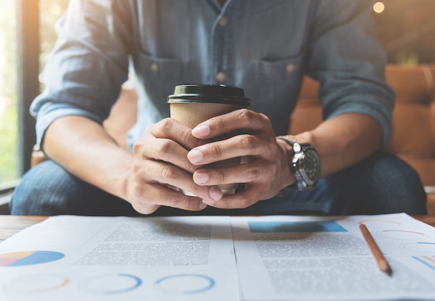 Freelance or businessman hands holding cup of coffee. 