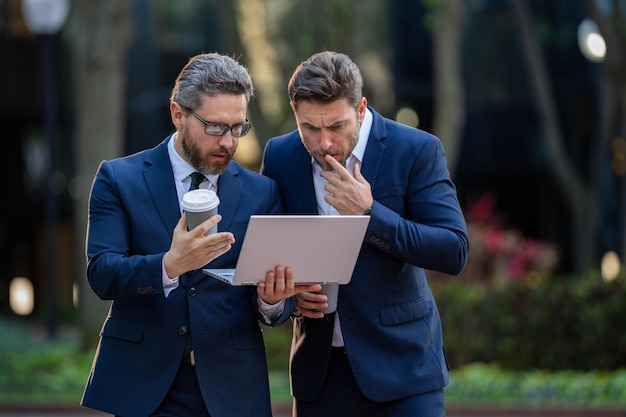 Freelance concept business men team using laptop outdoor two men talking in urban city center in