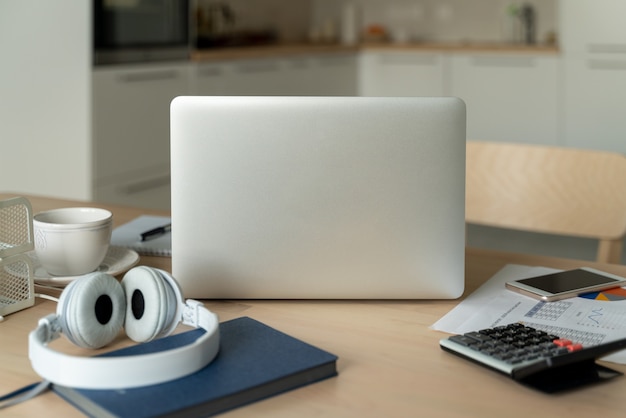 Freelance desk with laptop in kitchen room. Work from home. Distance education.