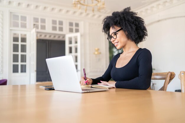 A freelance economist a woman with glasses works uses a laptop in the office makes a report with documents in a finance company