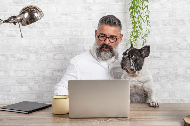 Внештатный человек, работающий из дома со своей собакой, сидит вместе в офисе