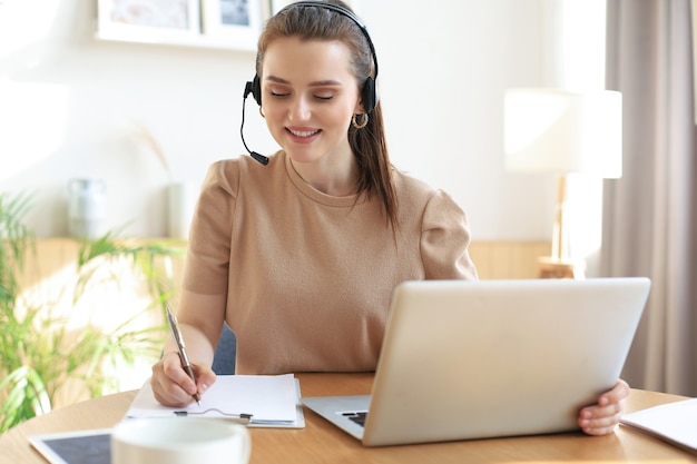 Freelance operator die met headsets praat en klanten raadpleegt vanuit een thuiskantoor.