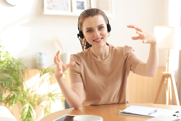 Freelance operator talking with headsets and consulting clients from home office.