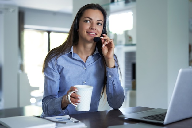 Freelance operator talking with headsets and consulting clients from home office.