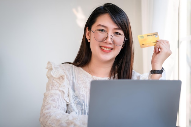 Freelance people business female casual show holding a credit card working with laptop computer in coffee shop like the background,for online shopping and payment via internet.