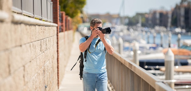 L'uomo del fotografo di viaggio freelance scatta fotografie utilizzando la fotocamera durante la fotografia delle vacanze estive