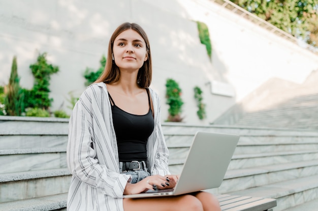 Freelance werkende vrouw in openlucht met laptop