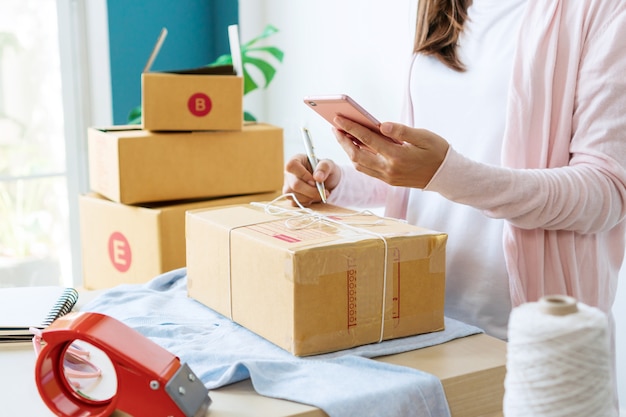 Freelance woman seller prepare parcel box of product for deliver to customer