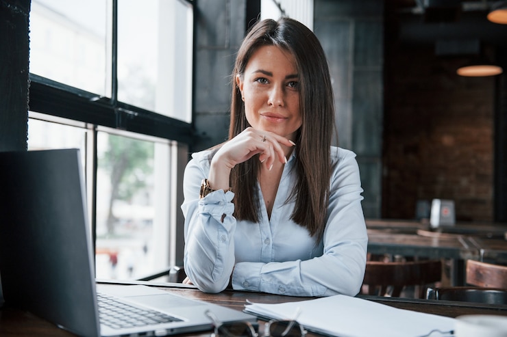 Photo freelance work. businesswoman in official clothes is indoors in cafe at daytime.