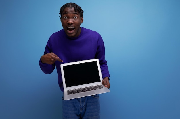 Freelancer african young brunette man with dreadlocks with laptop