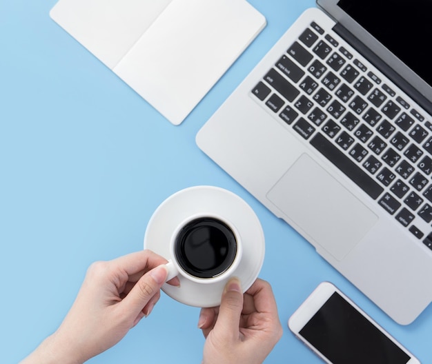 Freelancer blog schrijver vrouw drinken om te ontspannen op een schoon lichtblauw bureau met koffie werk thuis concept kopieerruimte plat lag bovenaanzicht mock up