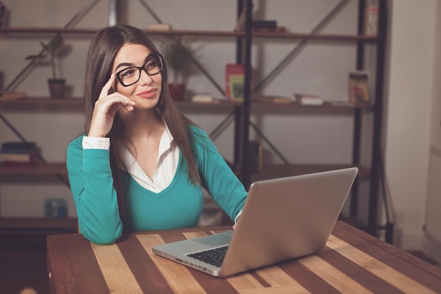 Freelancer denkt ergens aan en zit aan tafel