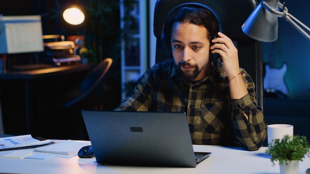 Freelancer die naar muziek luistert terwijl hij computeropdrachten uitvoert in het kantoor thuis