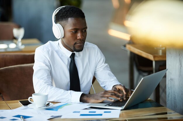 Freelancer in headphones working on report