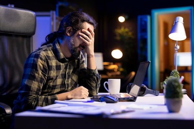 Freelancer holding his head at desk