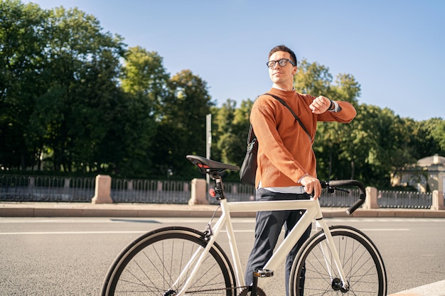 Freelancer is a millennial male cyclist riding a bicycle to work in casual clothes Eco transport