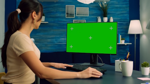 Freelancer looking for marketing information on internet using personal computer with mock up green screen chroma key