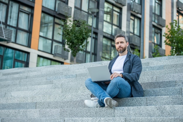 Freelancer man op straat met kopieerruimte freelancer man met pc buiten