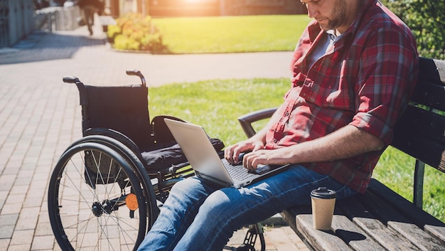 Freelancer met een lichamelijke beperking die gebruik maakt van een rolstoel die op het park werkt