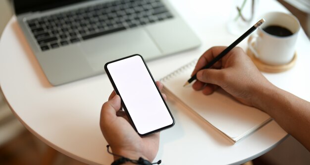 Freelancer schrijft zijn ideeën op laptop