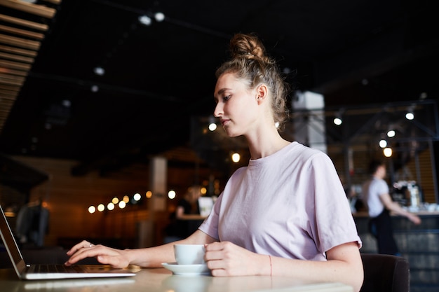 Freelancer using laptop in cafe