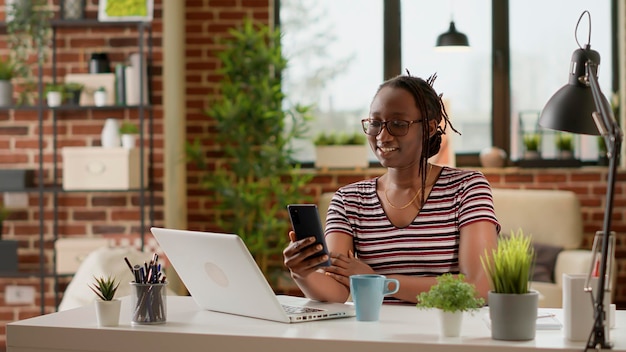 Freelancer using online videoconference call to talk to\
colleagues and do remote work on smartphone. businesswoman talking\
on virtual internet teleconference, using computer webcam.