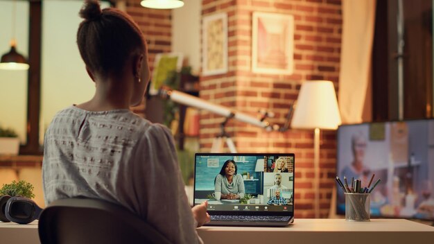 Photo freelancer on videocall with contractors using webcam to discuss remotely about new project tasks and deadlines. african american woman meets with clients, teleworking from home. handheld shot.