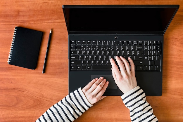 Freelancer werkplek bovenaanzicht vrouwelijke handen op het toetsenbord