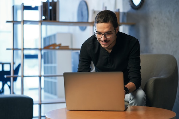 Libero professionista con laptop e gadget al tavolo che lavora o studente che utilizza tablet, smartphone e computer per l'istruzione