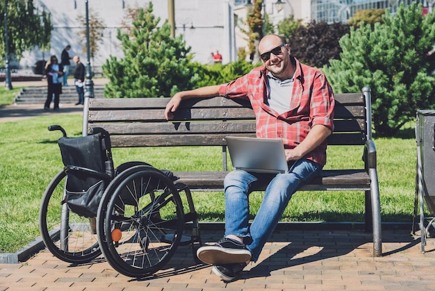 Freelancer with a physical disability in a wheelchair working at the park