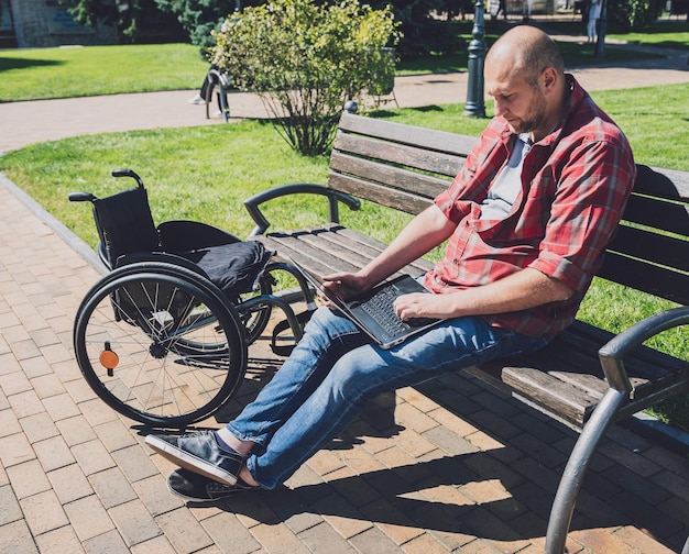 Freelancer with a physical disability in a wheelchair working at the park