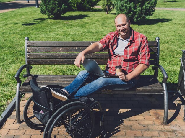 Freelancer with a physical disability in a wheelchair working at the park