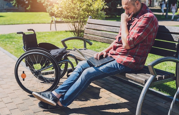 Freelancer with a physical disability in a wheelchair working
at the park