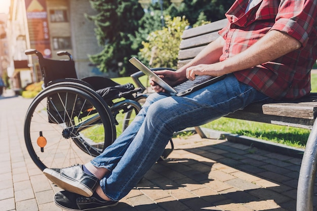 Libero professionista con disabilità fisica che utilizza la sedia a rotelle che lavora al parco