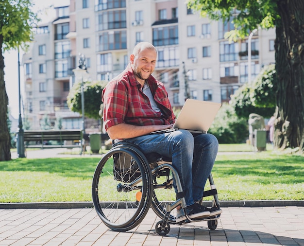 Freelancer with a physical disability who uses wheelchair working at the park