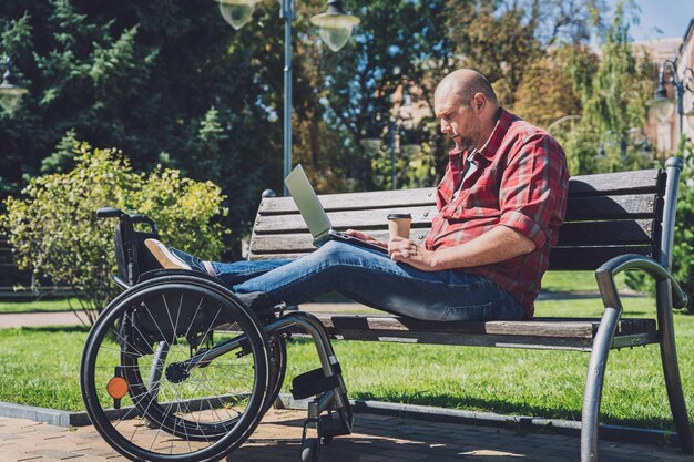 Freelancer with a physical disability who uses wheelchair working at the park