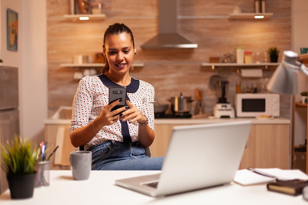 Freelancer woman having a conversation on phone while working\
from home late at night. employee using modern technology at\
midnight doing overtime for job, business, career, network,\
lifestyle ,wirele