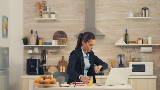 Donna libera professionista in ritardo in ufficio mentre fa colazione. giovane libera professionista che lavora 24 ore su 24 per raggiungere i suoi obiettivi, stile di vita stressante, fretta, tardi al lavoro, sempre in fuga