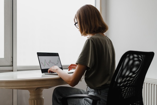 Freelancer Woman Using Laptop Computer sitting at home. Freelance Work, Business People Concept