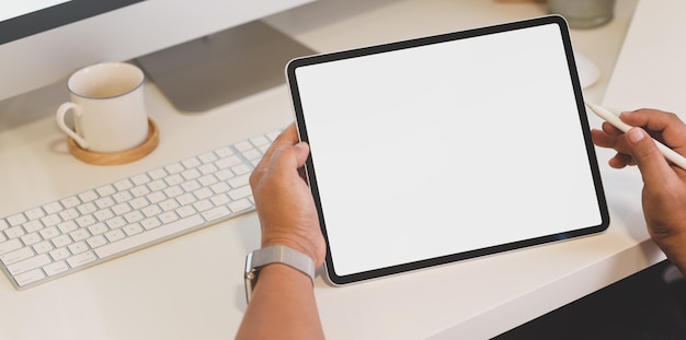 Freelancer working on his project with blank screen tablet