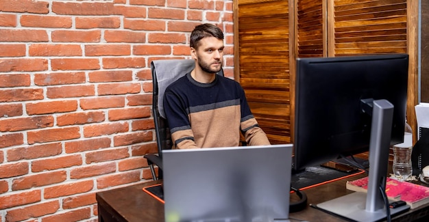 Freelancer working online on computer Handsome focused young man typing on keyboard