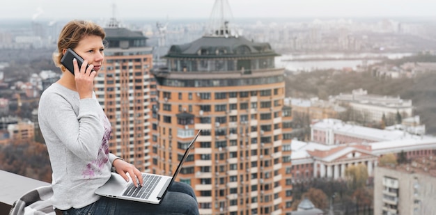 Freelancer working on the rooftop of skyscraper