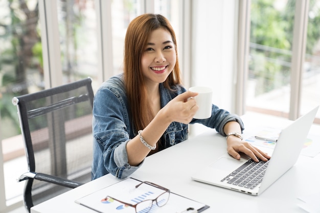 Freelancervrouw het drinken koffie met digitale laptop computer en het werken