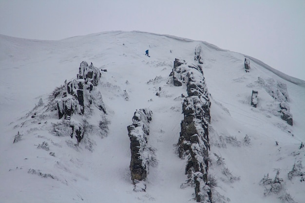 Freeride downhill op een steile en besneeuwde helling naast een besneeuwde kroonlijst in het hooggebergte